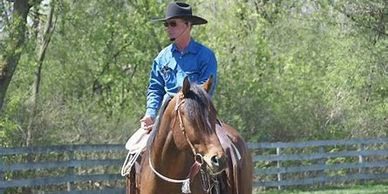 A man riding on the back of a brown horse.