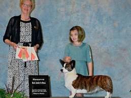 A woman and girl with a dog in front of them.