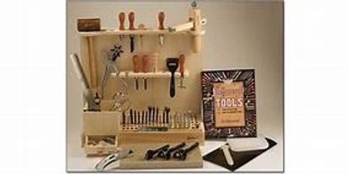 A wooden tool rack with many different tools on it.